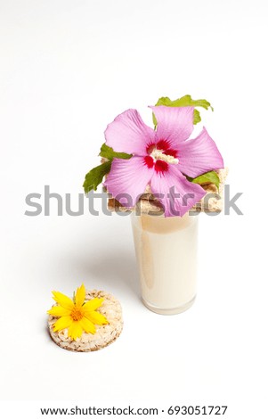 Two flowers, milk and delicious breads on a white background for a diet