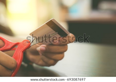 Hands cutting a credit card with scissors,copy space,vintage tone.