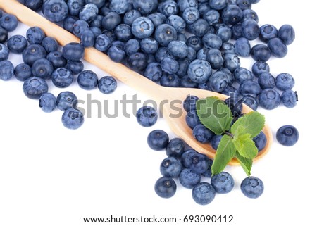 A big wooden spoon with organic blueberries and leaves of fresh mint, isolated on a white background. Copy space.