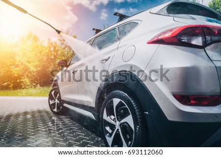 Manual car wash with pressurized water in car wash outside. Royalty-Free Stock Photo #693112060