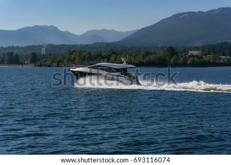 Speedboat riding in Indian Arm Inlet near Deep Cove, North Vancouver, British Columbia, Canada. Picture taken on a beautiful sunny summer day.