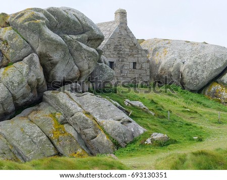 17th Century granite coast guard house between rocks. Meneham, Finistere, Brittany