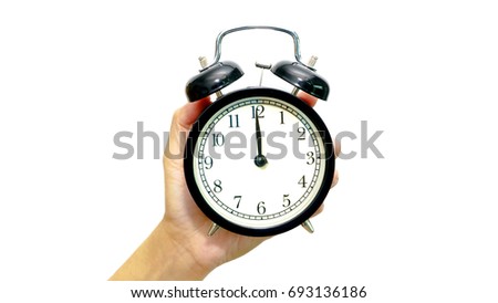 Hand hold an alarm clock with showing 12 o'clock. White background. Time concept.  Royalty-Free Stock Photo #693136186