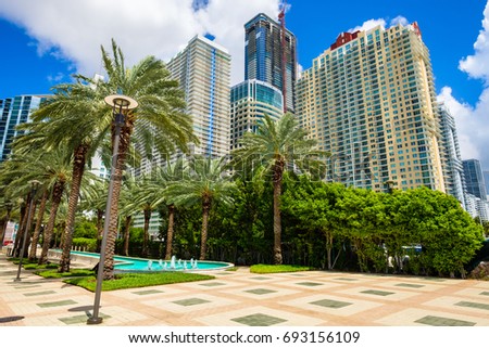Skyline view of the Brickell area in downtown Miami with palm trees and skyscrapers.