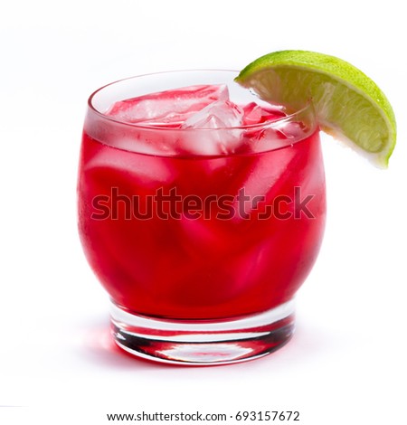 close up of a red cocktail served on the rocks garnished with a lime isolated on a white background