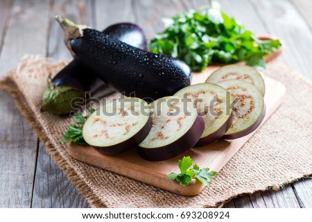 Sliced eggplant on wooden cutting board Royalty-Free Stock Photo #693208924