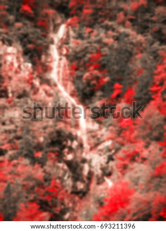 Blurred toned photo of stream in autumn forest. Abstract background.