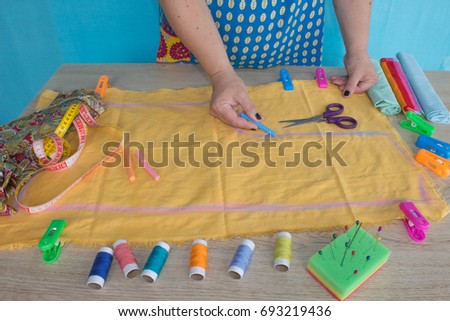closeup of woman hands sewing yellow cloth outdoors. Woman's Hand Sewing Quilt