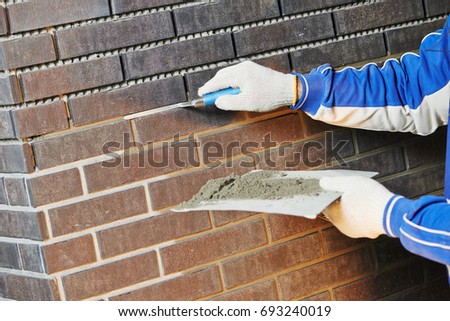 bricklaying Using the Brick Jointer Trowel Royalty-Free Stock Photo #693240019