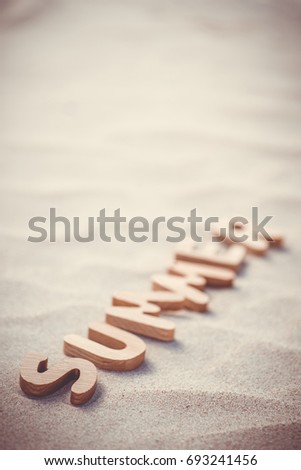 Summer. Wooden letters on the sand under the sun