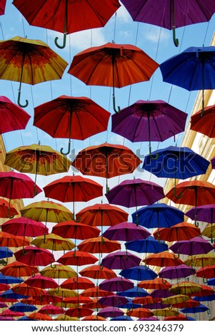 Street decorated with colorful umbrellas hanging in the sky