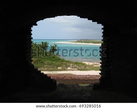 A picture perfect scene of the beach visible through a doorway in Fort Jefferson.