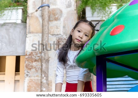 An Asian little girl is playing in the outdoor park