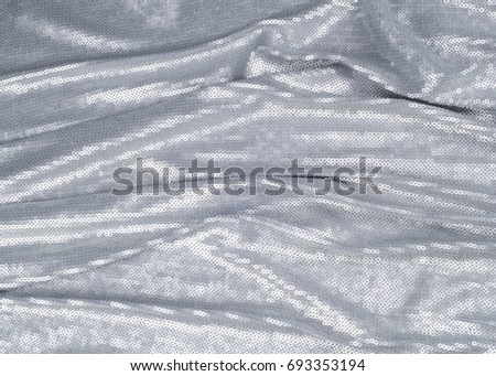 Silk fabric texture, background. Covered with sequins, silver color