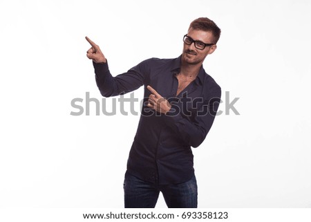 Young jocular man portrait of a confident businessman showing by hands on a gray background. Ideal for banners, registration forms, presentation, landings, presenting concept.