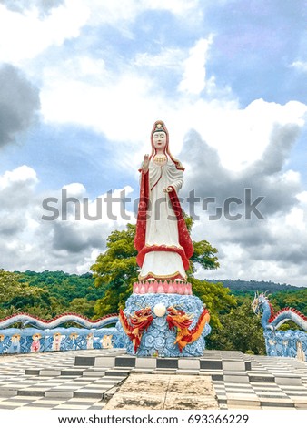 Statue of glorious goddess Kuan-in and sky with clouds.