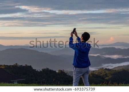 Unidentified man are capturing picture using smart phone
