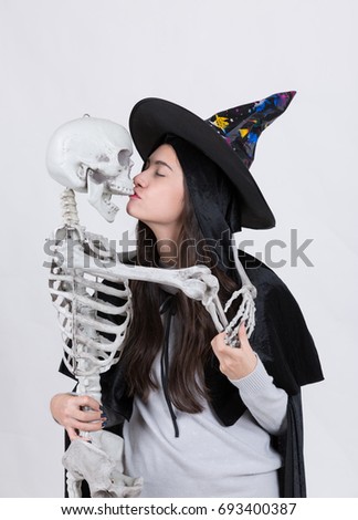 young woman kissing skeleton ,halloween concept.