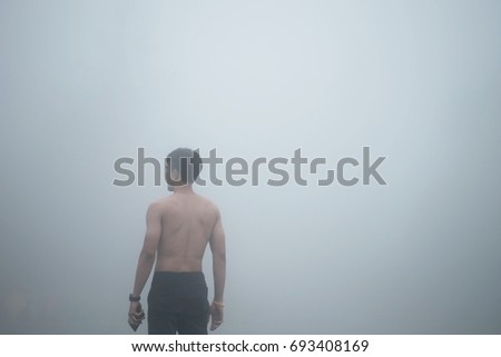 man standing in forest with fog after rain