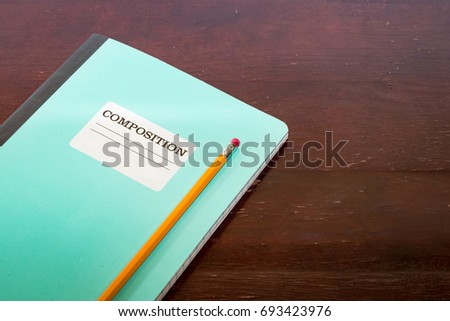Composition notepad and pencil on a table with lines for writing