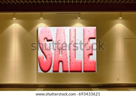 A wet perspiring sale signage illuminated by downlights in a window showcase for the concept: Sweaty Summer Sale.