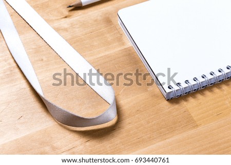 mock up of blank notebook, cd disc and badge on wooden office desk