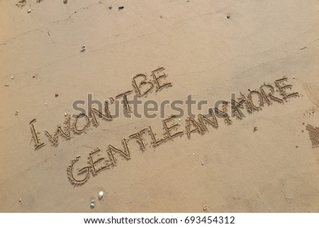 Handwriting  words "I WON'T BE GENTLE ANYMORE." on sand of beach.