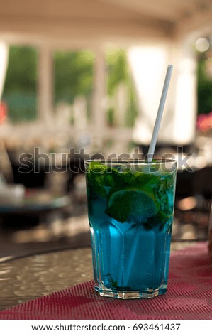 Tradition Summer drink blue mojito with lime mint and ice. Blue background