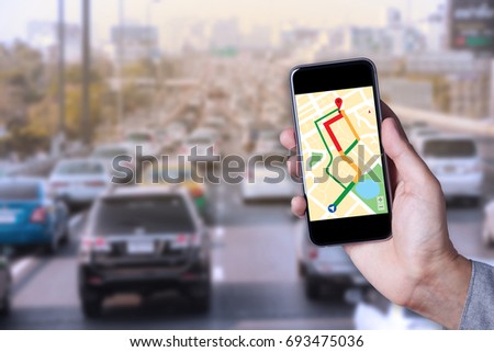 Hand of man using map on smartphone application with traffic jam background.