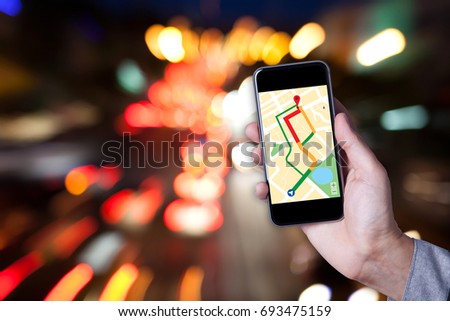 Hand of man using map on smartphone application with bokeh background of car on the road.