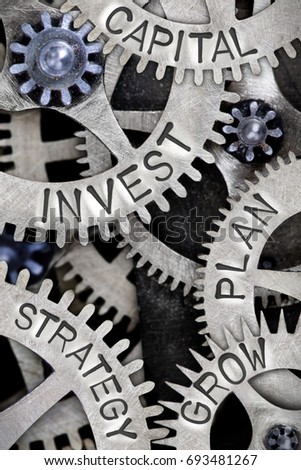 Macro photo of tooth wheel mechanism with INVEST, CAPITAL, STRATEGY, PLAN and GROW concept letters