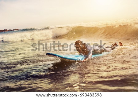 Handsome man has surfing on small waves. Mixed race dark skin and beard. Summer sport activity 