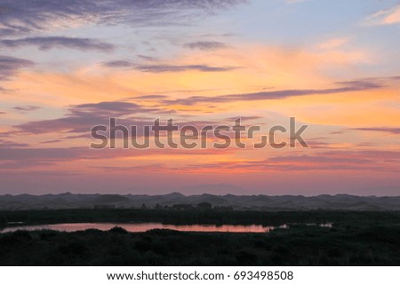 Sunset sky clouds.Countryside Landscape Under Scenic Colorful Sky At Sunset Dawn Sunrise. Sun Over Skyline, Horizon. Warm Colours.