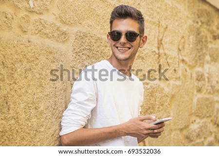 portrait of young smiling with the mobile phone in the city