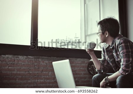 In selective focus to soft focus of Young businessman using tablet computer in classy coffee shop.Interior of coffee shop with customer using digital devices on free wifi internet service.