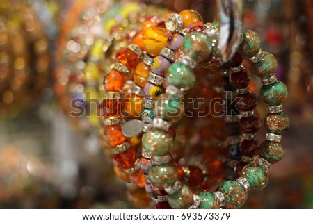 Beautiful bracelets made of murano glass hanged down in the shop window. Venice, Italy