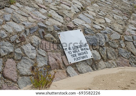 Warning sign on path being affected by coastal erosion