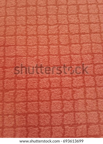 The background is made of orange patterned carpet fabric.