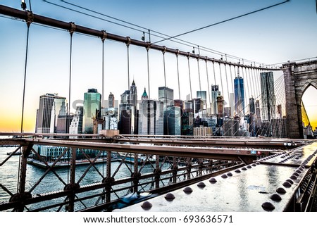 Cars speeding at sunset on Brooklyn Bridge, Manhattan. One of the most iconic bridges in the world, a must see attraction when visiting New York.