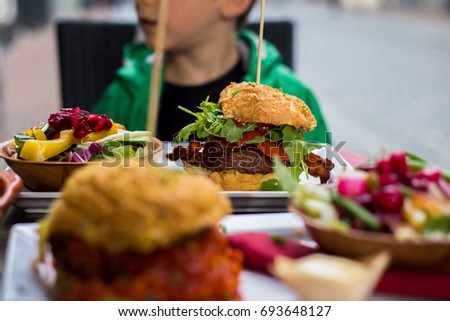 The big burger and  boy. Shallow depth of field.