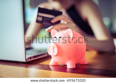 pink color Pig save bank with woman holding credit card using internet computer on background, money discount saving shopping on line concept. Royalty-Free Stock Photo #693671020