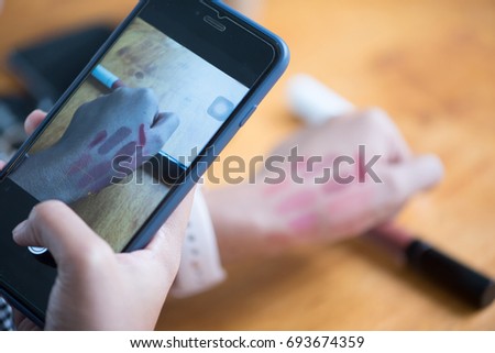 A woman is trying out cosmetics or woman try new color lipstick with her hand.
