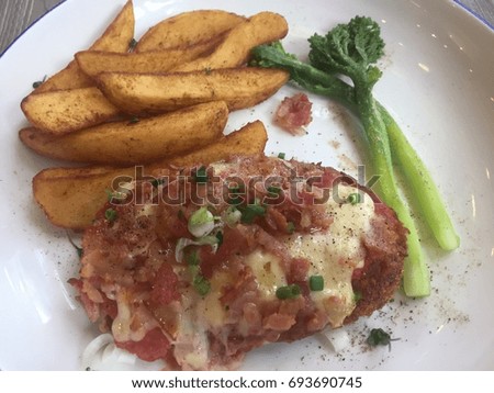 amazing beautiful fried chicken topped with mixed sauce served with fried potatoes and green vegetables picture