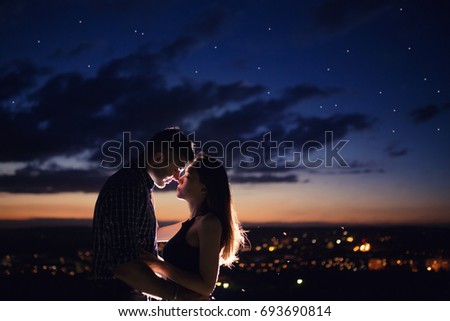 Lovers man and girl against background night city, night starry sky and horizon. Concept date Valentine's Day, first kiss love, forever together. Royalty-Free Stock Photo #693690814