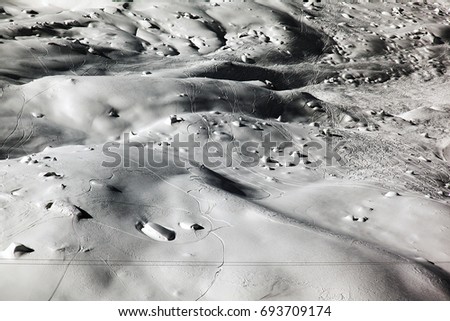 Ski and snowboard marks and snow balls in the snow covered mountains of Switzerland