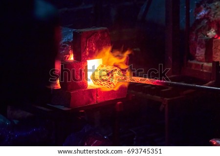 Get the hot metal from the forge furnace, the tongues of flame Royalty-Free Stock Photo #693745351