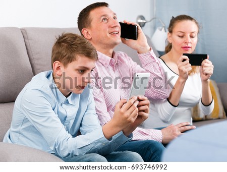 Family members spending time playing with smartphones at home