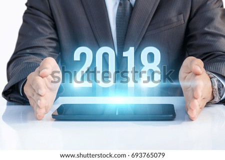 Businessman on tablet shows 2018 . The concept of a new year.
