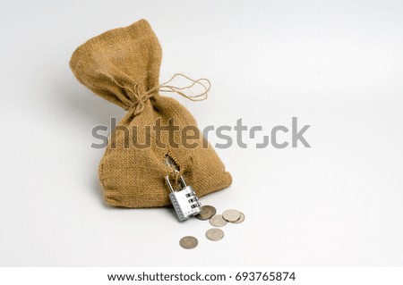 Combination lock is locking damaged money bag to prevent from coins leaking out, concept of business and financial security.