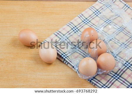 Eggs in the panel with towel on wooden background